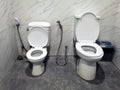 Two toilet seats installed together in one bathroom, a big one is for adults and a small one is for kids. Restroom with two toilet