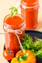 Two tomato smoothies in a glass jar with the ingredients for its preparation. Fresh tomatoes, bell peppers and lettuce on a dark Royalty Free Stock Photo