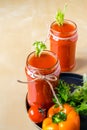 Two tomato smoothies in a glass jar with the ingredients for its preparation. Fresh tomatoes, bell peppers and lettuce on a dark Royalty Free Stock Photo