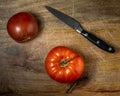 Two tomatoes and a knife on a cutting board Royalty Free Stock Photo