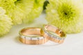 Two-tone wedding rings with green flowers Royalty Free Stock Photo