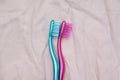 Two toothbrushes arranged like couple on bed spooning