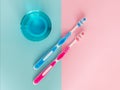 Two toothbrushes and mouthwash on a pink and blue background. The concept of daily dental care