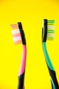 Two toothbrushes pink and green on a yellow background, oral hygiene Royalty Free Stock Photo