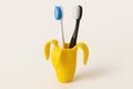 Two toothbrushes in a yellow banana-shaped stand. Space for text. Royalty Free Stock Photo