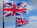 Two torn British Union Jack flags fluttering in the strong breeze Royalty Free Stock Photo