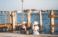 Two tourist girls sitting on the waters edge and enjoying the idyllic scene on Grand Canal in Venice