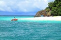 Two tourist sitting on red boat travel to beautiful island with white sand, long beach and stone canal at Krabi, Thailand