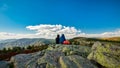 Two tourist sitting on a rock and watching colorful treeless mountain landscape, Jeseniky, Czech Republic