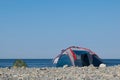 Two tourist tents on a pebble sea shore in the morning Royalty Free Stock Photo