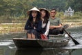 Two tourist women and the rower on a tour along the river in Tam Coc