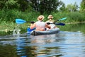 Two tourists are floating on the river in a canoe