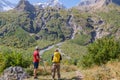 Two tourists are going to climb up the mountain to the waterfalls, inspect the area. Royalty Free Stock Photo