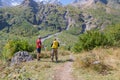 Two tourists are going to climb up the mountain to the waterfalls, inspect the area. Royalty Free Stock Photo