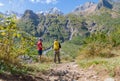 Two tourists are going to climb up the mountain to the waterfalls, inspect the area. Royalty Free Stock Photo