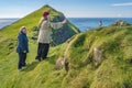 Two tourists making photos with their smartphone of puffins birds at Mykines island at Faroe islands archipelago and Atlantic