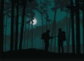 Two tourists, man and woman wandering the night forest with map, under the sky with moon Royalty Free Stock Photo