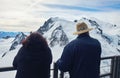 Two tourists on Mount Aiguille du Midi admire the Mont Blanc Massif