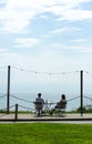 Two tourists sit at a table on the promenade, looking out to sea, at the charming Welsh seaside resort of Criccieth