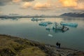 Two tourists stand at Fjallsarlon Lagoon and Iceberg in vatnajokul National Park in southern Iceland Royalty Free Stock Photo