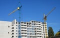 Two tower cranes are erecting a high rise building, residential apartment building. A new apartment building under construction Royalty Free Stock Photo