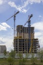 Two tower cranes near a modern high-rise building under construction Royalty Free Stock Photo
