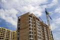 Two tower cranes working on high rise brick building under construction on blue sunny sky copy space background. Modern urbane ar Royalty Free Stock Photo