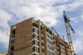 Two tower cranes working on high rise brick building under construction on blue sunny sky copy space background. Modern urbane arc Royalty Free Stock Photo