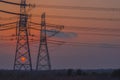 Two towering high-voltage lines greet the setting sun.