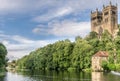 Two towers sticking up through a forest and a boat house and bridge Royalty Free Stock Photo