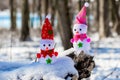 Two toy snowmen in the forest in sunny weather Royalty Free Stock Photo