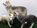 Three toy wolf figures on green grass Royalty Free Stock Photo