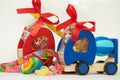 Two toy wooden trucks with gift chocolate and rainbow candies on the white background. Childhood