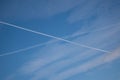 Two traces from planes crossing in the sky blue sky with some thin clouds Royalty Free Stock Photo