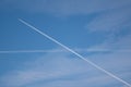 Two traces from planes crossing in the sky blue sky with some thin clouds Royalty Free Stock Photo