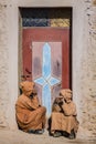 Two typical Moroccans talking in front of a door from a small village house.