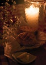 Two traditional polish breads on a piece of paper. Next to them there is a candle and some butter. The scene is elegant and romant