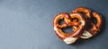 Two traditional soft Octoberfest pretzels on black background, banner Royalty Free Stock Photo