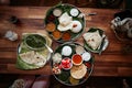 Two traditional steel plates with indian thali and plate with spinach with cheese