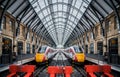 Two trains symmetrical mirrored in London Kings Cross Station deserted platforms with train waiting on each track and no passenger Royalty Free Stock Photo