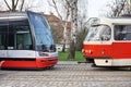 Two tram carriages with one very modern and one outmoded as a contrast of new and old