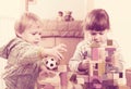 Two tranquil children playing with wooden blocks