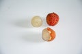 Two translucent peeled lychees and one shelled lychee on a pure white background Royalty Free Stock Photo