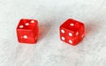 Two translucent red craps dices on white board showing Easy Four number 3 and 1