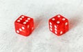 Two translucent red craps dices on white board showing Easy Ten number 6 and 4