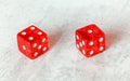 Two translucent red craps dices on white board showing Fever Five number four and one