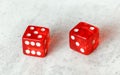 Two translucent red craps dices on white board showing Natural or Seven Out number 5 and 2
