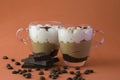 two transparent cups with cappuccino coffee, coffee grains and a bar of chocolate Royalty Free Stock Photo