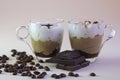 two transparent cups with cappuccino coffee, coffee grains and a bar of chocolate Royalty Free Stock Photo