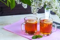 Two transparent cups with tea. Green, black, herbal, jasmine tea